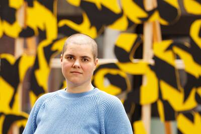 Künstlerin steht vor ihren Arbeiten