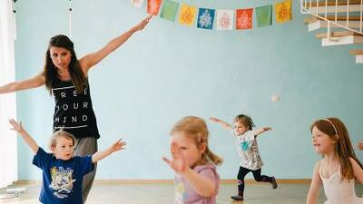 Kinder und Erzieherin tanzen